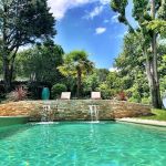 Piscine avec vue panoramique dans un jardin richement arbor&eacute;